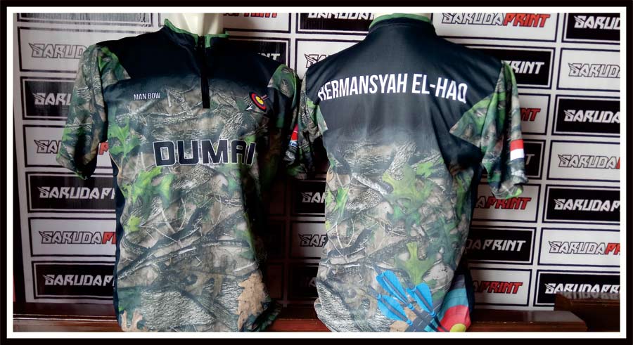Siap, ini versi artikel yang sudah diganti.

# Jersey Panahan Dumai Tampil Tangguh dengan Zipper Pendek dan Motif Camo

**Meta Title:** Jersey Panahan Dumai by Garuda Print
**Meta Description:** Garuda Print menghadirkan jersey panahan Dumai dengan motif camo hijau, warna gelap, dan detail zipper pendek yang tampil sporty.
**Slug:** `jersey-panahan-dumai-garuda-print`

## Jersey Panahan Dumai Selesai Dibuat

Garuda Print kembali menghadirkan hasil pengerjaan jersey untuk kebutuhan olahraga panahan.

Kali ini, desain dibuat untuk **Dumai**. Jersey ini tampil dengan kombinasi warna **hitam, hijau, dan abu-abu** yang kuat.

Motif camo membuat tampilannya terlihat tangguh, aktif, dan berbeda dari jersey olahraga biasa.

## Detail Zipper Pendek yang Sporty

Salah satu detail utama pada jersey ini ada di bagian kerah.

Jersey memakai **zipper pendek** di bagian depan. Detail ini membuat tampilan terlihat lebih sporty dan modern.

Model seperti ini cocok untuk jersey panahan karena memberi kesan rapi, praktis, dan tetap nyaman digunakan saat bergerak.

## Motif Camo yang Kuat

Bagian badan jersey memakai motif camo bernuansa hijau dan abu-abu.

Warna hitam pada bagian atas memberi kesan lebih solid. Perpaduan ini membuat jersey terlihat tegas dari depan maupun belakang.

Tulisan **Dumai** pada bagian depan dibuat besar dan jelas. Detail pada lengan juga menambah identitas visual jersey.

## Tampilan Belakang Tetap Konsisten

Bagian belakang jersey tetap membawa konsep desain yang sama.

Motif camo dibuat menyatu dengan bagian depan. Pada area atas belakang, terdapat detail nama yang tampil jelas dengan warna putih.

Hasil akhirnya membuat jersey terlihat rapi, kuat, dan siap digunakan untuk kebutuhan tim panahan.

## Garuda Print Siap Dukung Jersey Panahan

Jersey panahan membutuhkan desain yang rapi dan punya identitas kuat.

Garuda Print siap membantu membuat jersey sesuai kebutuhan tim, komunitas, maupun kegiatan olahraga. Mulai dari warna, motif, logo, tulisan, hingga model kerah bisa disesuaikan dengan konsep yang diinginkan.

**Caption gambar:**
Jersey panahan Dumai by Garuda Print dengan motif camo hijau, warna gelap, dan detail zipper pendek yang tampil sporty.
